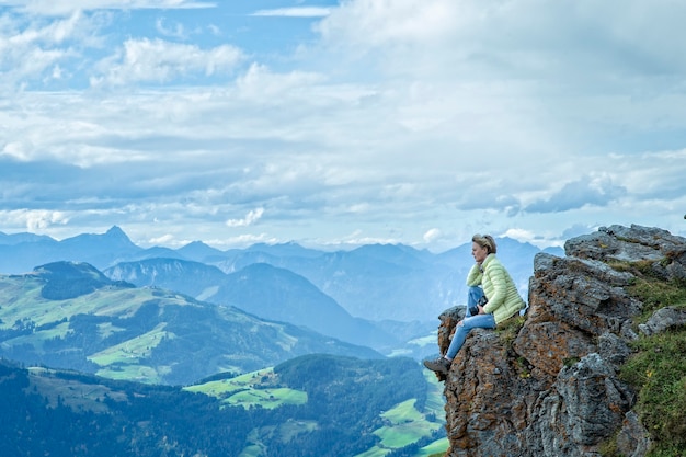 Una mujer sentada sobre una roca Alpes Austria