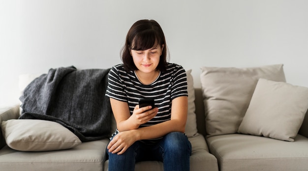 Mujer sentada en un sofá con smartphone