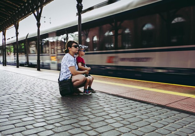 Foto mujer sentada en el tren en la estación de tren