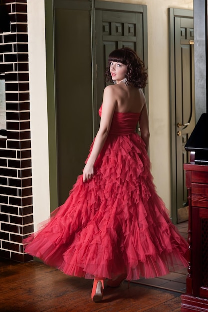 Mujer sentada en vestido de noche rojo