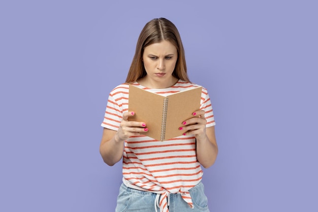 Una mujer seria y concentrada sosteniendo y leyendo un libro impresionada por la trama lee con atención