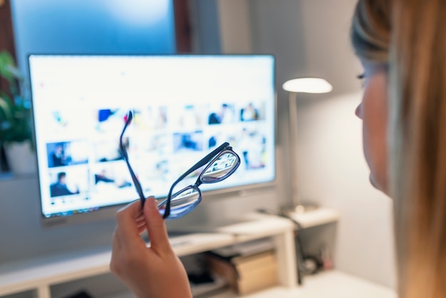 Mujer seria joven con gafas mirando pc