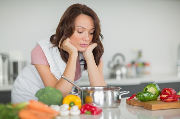 Mujer seria preparando comida en la cocina