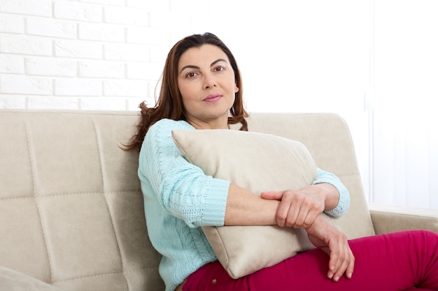 mujer seria sentada en casa.