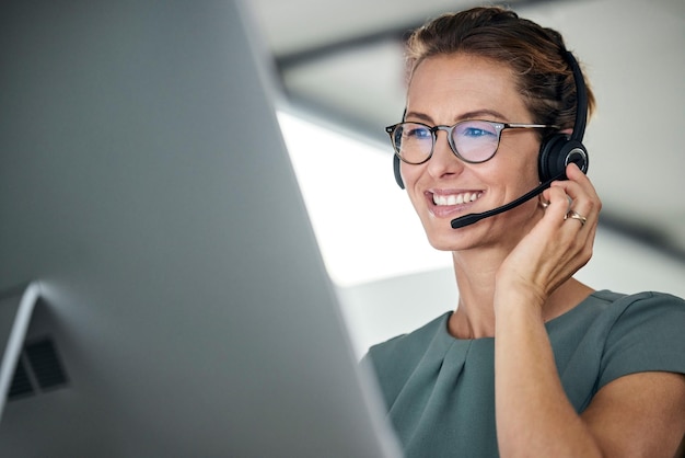 Foto mujer de servicio al cliente y feliz agente del centro de llamadas dando consejos en línea usando un auricular telemarketing del operador y soporte con un consultor de línea directa que trabaja para contactarnos ayuda o consultoría de brazos