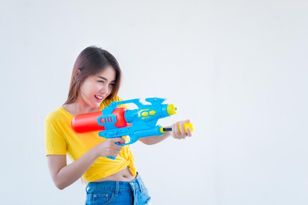 Mujer sexy asiática con agua en la mano sobre fondo blancoDía del festival songkran en tailandiaLo mejor del festival de tailandiaTierra de la sonrisa