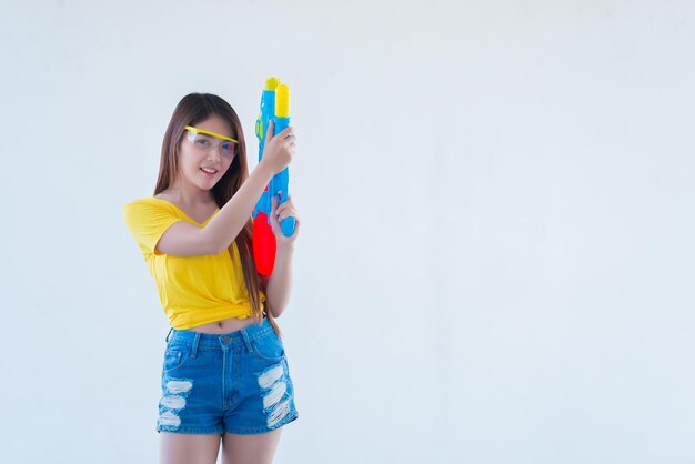 Mujer sexy asiática con agua en la mano sobre fondo blancoDía del festival songkran en tailandiaLo mejor del festival de tailandiaTierra de la sonrisa