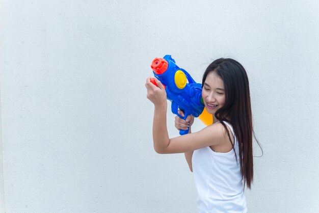 Mujer sexy asiática con agua en la mano sobre fondo blancoDía del festival songkran en tailandiaLo mejor del festival de tailandiaTierra de la sonrisa