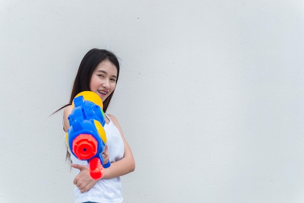 Mujer sexy asiática con agua en la mano sobre fondo blancoDía del festival songkran en tailandiaLo mejor del festival de tailandiaTierra de la sonrisa