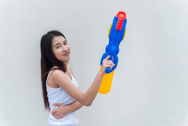 Mujer sexy asiática con agua en la mano sobre fondo blancoDía del festival songkran en tailandiaLo mejor del festival de tailandiaTierra de la sonrisa