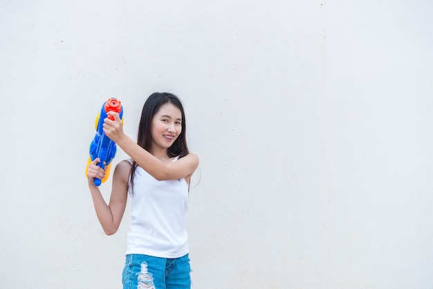 Mujer sexy asiática con agua en la mano sobre fondo blancoDía del festival songkran en tailandiaLo mejor del festival de tailandiaTierra de la sonrisa