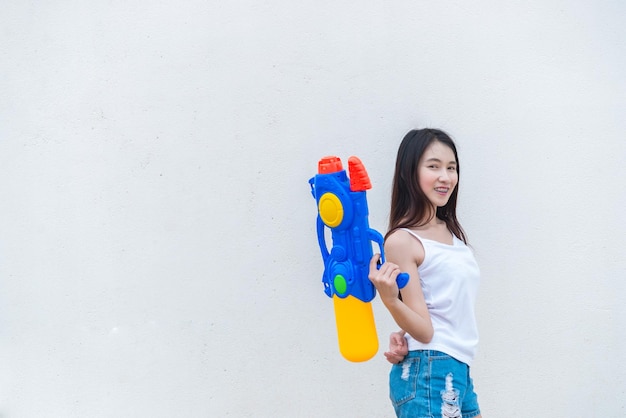 Mujer sexy asiática con agua en la mano sobre fondo blancoDía del festival songkran en tailandiaLo mejor del festival de tailandiaTierra de la sonrisa