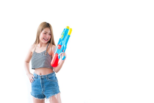 Mujer sexy asiática con agua de pistola en la mano sobre fondo blancoDía del festival songkran en tailandiaLo mejor del festival de tailandiaTierra de la sonrisa