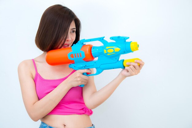 Mujer sexy asiática con agua de pistola en la mano sobre fondo blancoDía del festival songkran en tailandiaLo mejor del festival de tailandiaTierra de la sonrisa