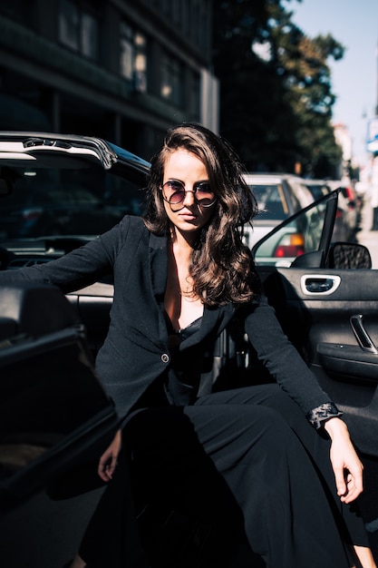 Mujer sexy de cabello castaño en el asiento del auto