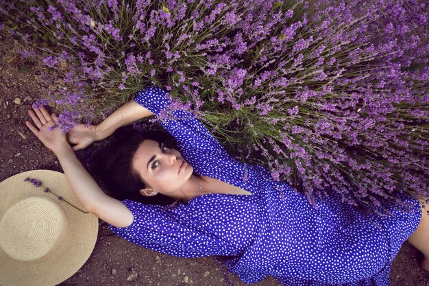 Mujer sexy en campos florecientes de lavanda al atardecer disfrutando de la naturaleza