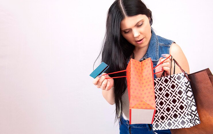 Foto mujer sexy de compras hermosa chica con cabello negro sosteniendo bolsas de compras y tarjeta de crédito aisladas sobre fondo blanco