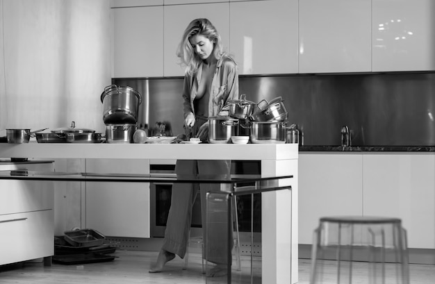 Foto mujer sexy cortando ingredientes para pizza, queso y salchichas, mujer sexy en la cocina por la mañana
