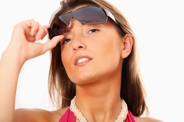 Una mujer sexy con gafas de sol sobre fondo blanco.