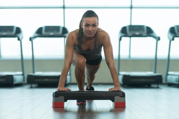 Mujer sexy haciendo flexiones en el piso