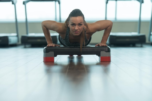 Foto mujer sexy haciendo flexiones en el piso