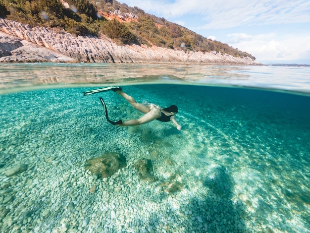 Mujer sexy nadando bajo el agua en máscara de buceo con aletas vacaciones de verano