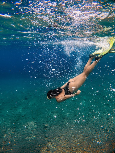 Mujer sexy nadando bajo el agua en máscara de buceo con aletas vacaciones de verano