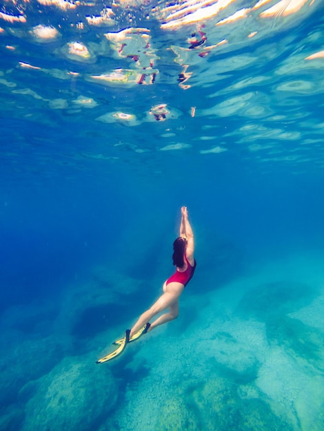 Mujer sexy nadando bajo el agua en máscara de buceo con aletas vacaciones de verano