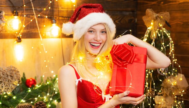 Mujer sexy con sombrero de santa con regalo de navidad