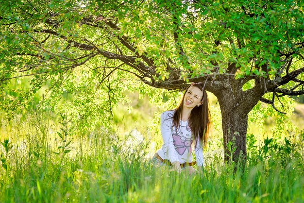 una mujer se sienta bajo un árbol en la hierba