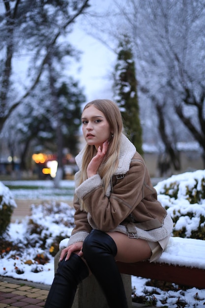 una mujer se sienta en un banco en la nieve