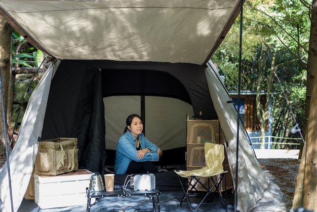 Foto la mujer se sienta dentro de la tienda de campamento y mira afuera