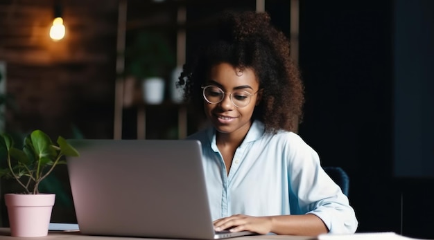 Una mujer se sienta en un escritorio con una computadora portátil frente a ella.