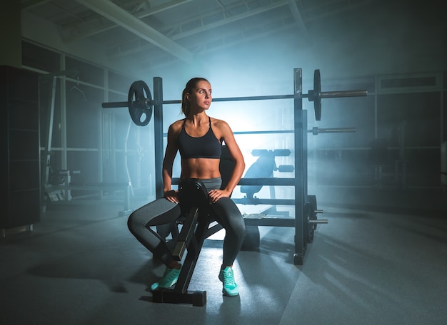 La mujer se sienta en el gimnasio.