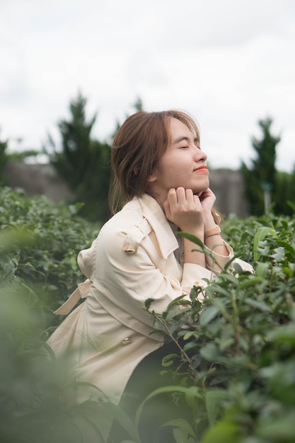 Una mujer se sienta en un jardín verde, sonriendo y mirando a la cámara.