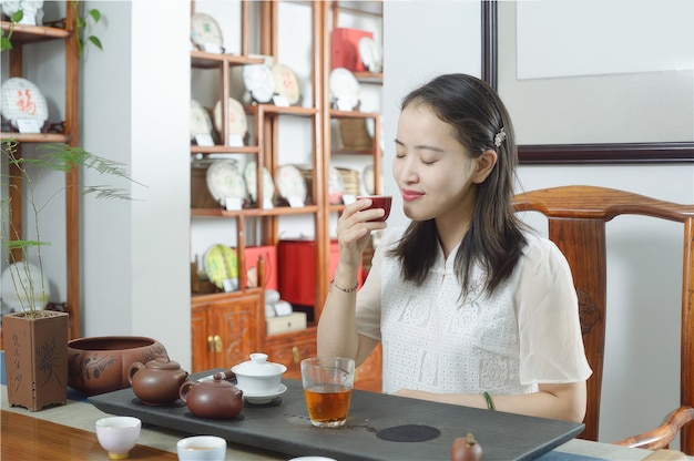 Una mujer se sienta en una mesa bebiendo té y disfruta de una taza de té Té para relajarse y rejuvenecer