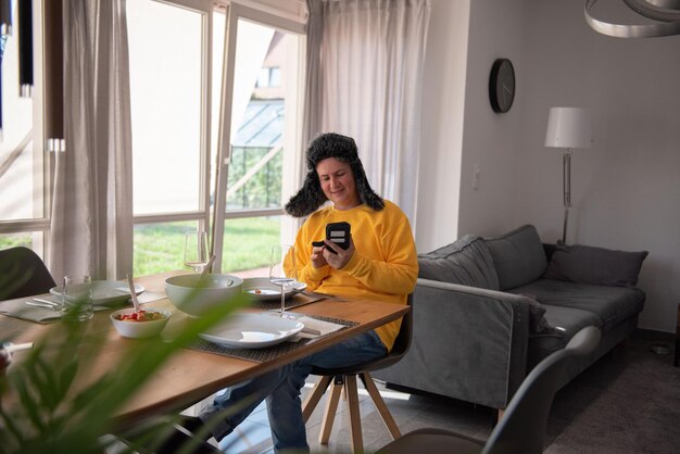 Foto una mujer se sienta en la mesa de comedor vestida cálidamente y come