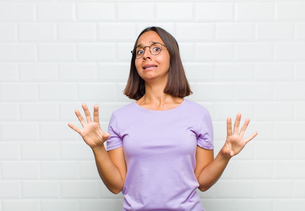 La mujer se siente estupefacta y asustada, temiendo algo aterrador, con las manos abiertas al frente