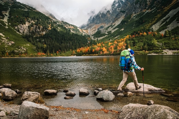 La mujer siente la libertad y disfruta de la naturaleza dorada del otoño en la montaña