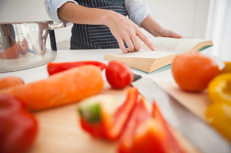 Foto mujer siguiendo una receta en el libro