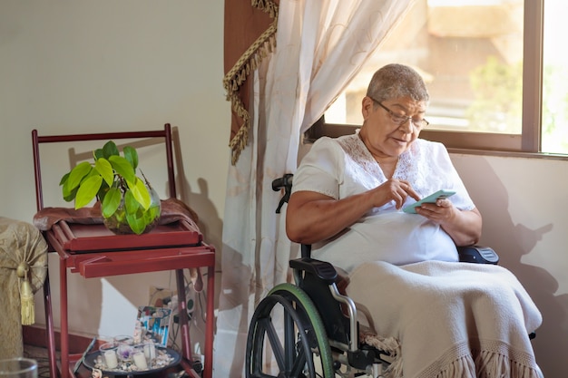 Mujer en silla de ruedas charlando por teléfono celular