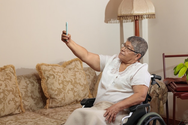 Mujer en silla de ruedas tomando una foto selfie