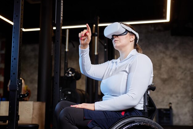 Mujer en silla de ruedas con VR en un club de fitness