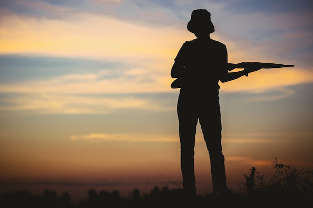 Mujer de silueta triste en la montaña en filtro de puesta de sol y vintage