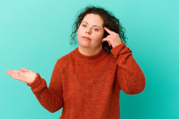 Mujer con síndrome de Down aislada mostrando un gesto de decepción con el dedo índice.