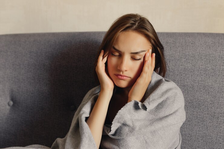 Mujer sintiendo dolor de cabeza, cerró los ojos, sosteniendo las manos en las sienes, sintiéndose enferma. Concepto de problema de salud.