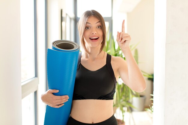 mujer sintiéndose como un genio feliz y emocionado después de realizar una idea, levantando alegremente el dedo, ¡eureka!