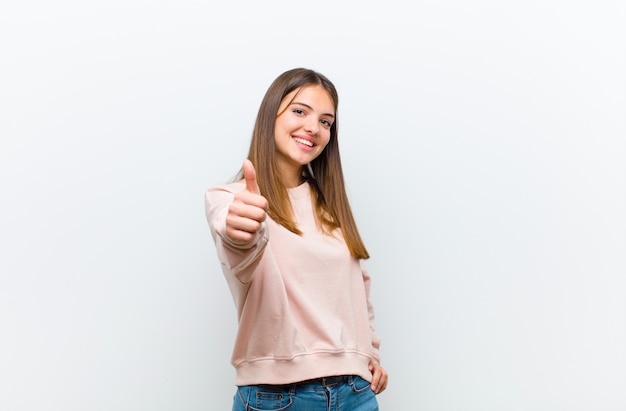 mujer sintiéndose orgullosa, despreocupada, segura y feliz, sonriendo positivamente con los pulgares arriba