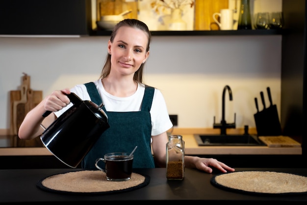 Una mujer sirviendo café en una taza