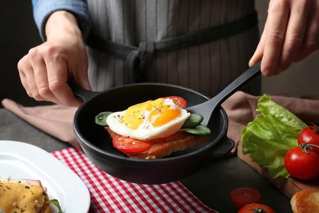 Mujer sirviendo huevo Benedict para desayunar en la mesa